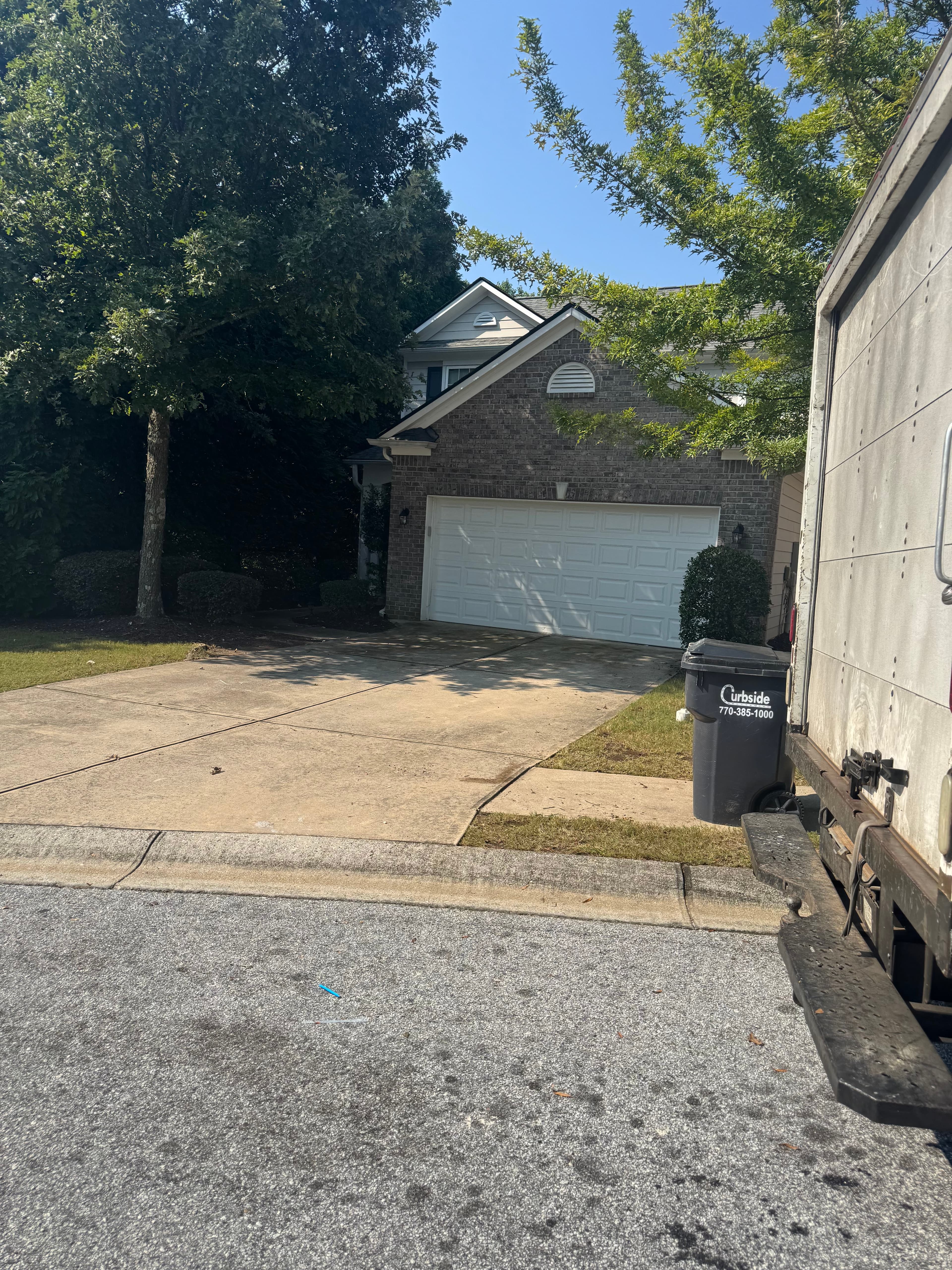 Clear driveway and front approach after pickup with the house exterior visible and no debris left behind.