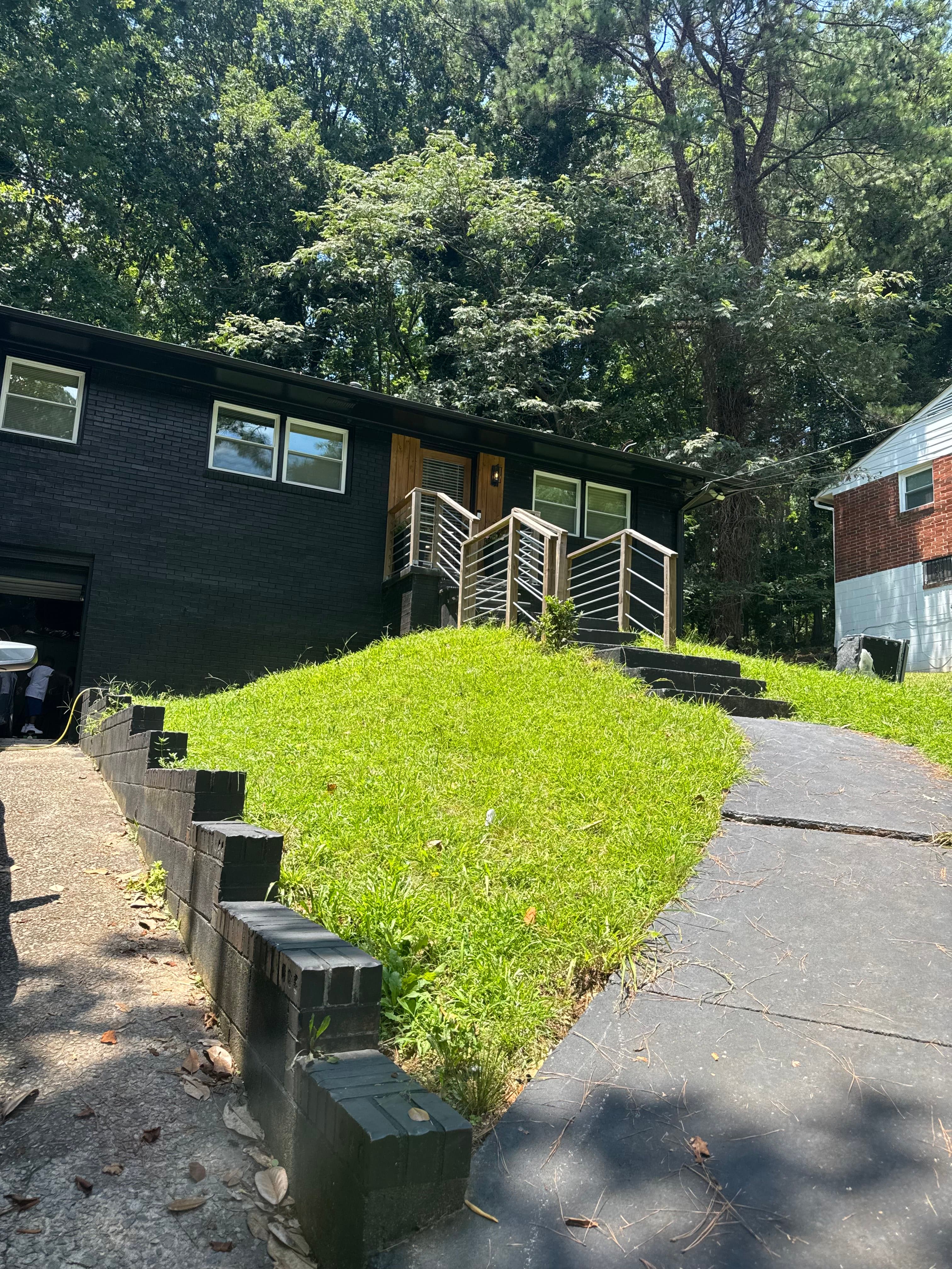 Clean residential exterior after junk removal with the front slope and driveway opened back up.